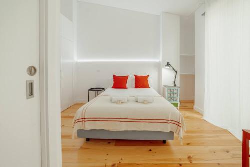 um quarto branco com uma cama grande e almofadas vermelhas em Modern Villa by Hosty no Porto