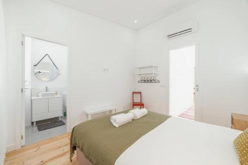 um quarto branco com uma cama e um lavatório em Modern Villa by Hosty no Porto