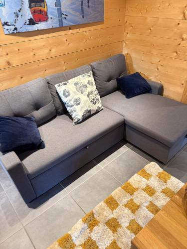 um sofá cinzento com almofadas numa sala de estar em Modern Comfortable Chalet with large terrace em Morzine