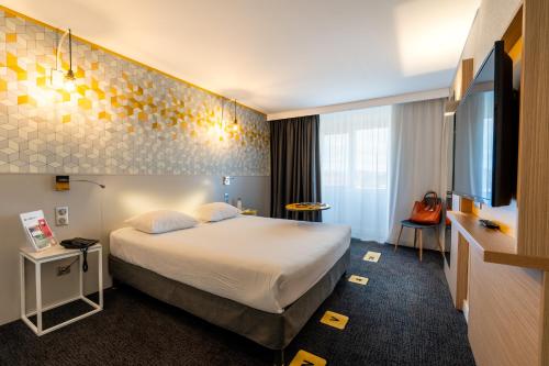 מיטה או מיטות בחדר ב-ibis Styles Poitiers Nord