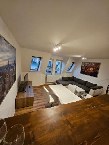 un soggiorno con divano e tavolo di FERIENWOHNUNG APARTMENT 2 RAUM MAISONETTEN WOHNUNG im ZITTAUER STADTZENTRUM INNENSTADT INNENRING TOP LAGE MARKT UND RATHAUS NÄHE a Zittau