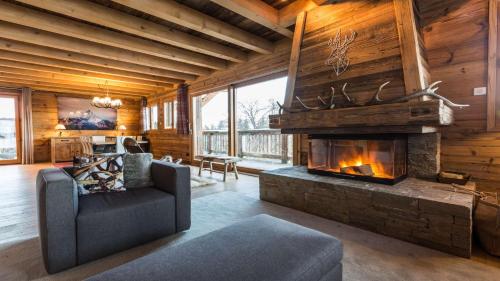 ein Wohnzimmer mit einem Kamin in einem Blockhaus in der Unterkunft Chalet de ski avec piscine - Megève in Megève