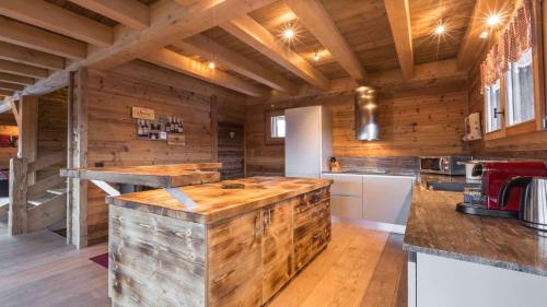 eine Küche mit Holzwänden und Holzböden in der Unterkunft Chalet de ski avec piscine - Megève in Megève