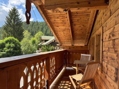 eine Veranda einer Hütte mit 2 Stühlen in der Unterkunft Das Anja Alt Filzmoos in Filzmoos