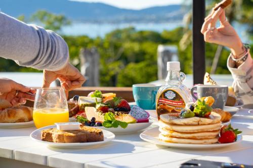 uma mesa com comida para o pequeno-almoço e uma garrafa de sumo de laranja em Freedom Shores Resort Airlie Beach em Airlie Beach