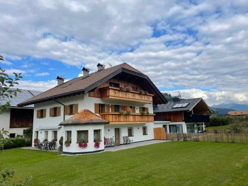 una grande casa con un prato verde davanti di App Unterhoelzlhof - Chalet Anima a Valdaora