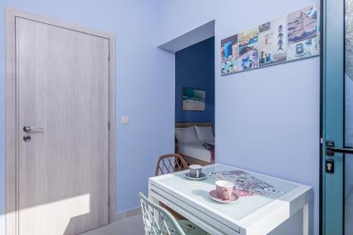 a room with a white table and chairs and a door at M City Apartments 100m from the beach in Chania Town