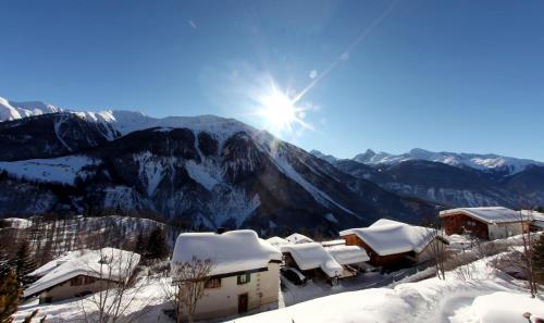 zimowy widok na góry z pokrytymi śniegiem dachami w obiekcie Aparthotel Muchetta w Davos