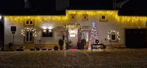 uma árvore de Natal em frente a um edifício com luzes em El-Rei Dom Manuel Hotel em Marvão