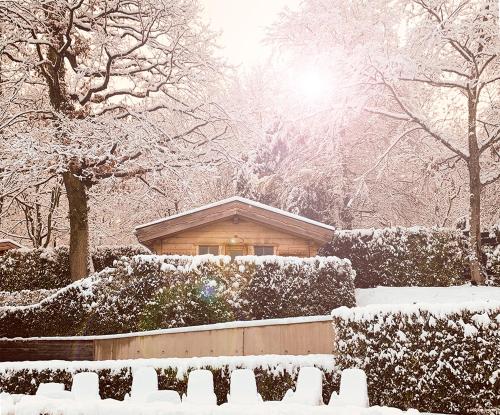 une maison recouverte de neige dans une cour dans l'établissement Mondorf Parc Hotel & Spa, à Mondorf-les-Bains