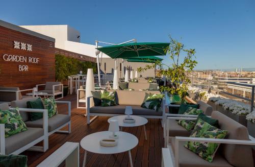 un patio en la azotea con sofás y mesas en un edificio en Altis Grand Hotel, en Lisboa