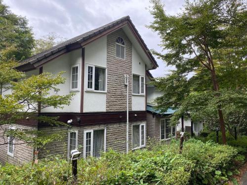 una casa antigua con ventanas blancas y árboles en Klingelbaer, en Hakone