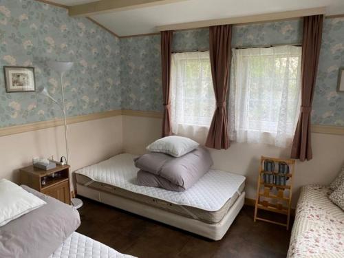 1 dormitorio con 2 camas y 2 ventanas en Klingelbaer, en Hakone