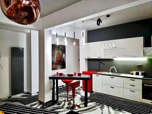 a kitchen with a table and red chairs in it at fruit tower 300Mbps in Thessaloniki