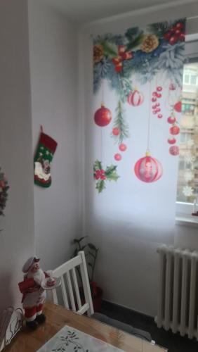 ein Esszimmer mit Weihnachtsdekoration an der Wand in der Unterkunft Apartman Zlatovo Stan Na Dan in Požarevac