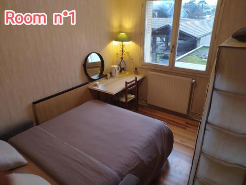 een slaapkamer met een bed en een bureau met een spiegel bij Chambres dans appartement partagé in Grenoble