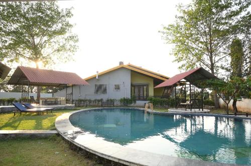 uma piscina em frente a uma casa em Salsa Villa em Nashik