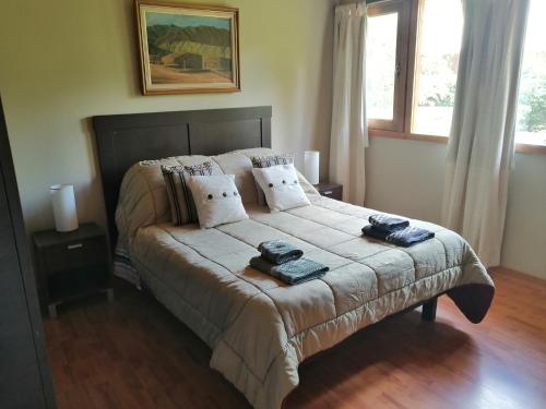 um quarto com uma cama com duas toalhas em Bed and Breakfast Como en Casa em Villa La Angostura