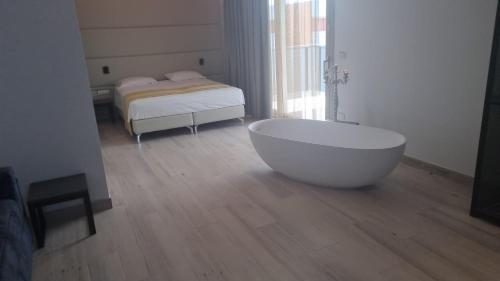 ein Bad mit einer Badewanne und einem Bett in der Unterkunft HOTEL VENICE BEACH HVB 34 Lifestyle 4 Superior in Bibione