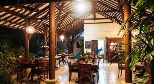 um restaurante com mesas e cadeiras de madeira num edifício em Alam Sari Keliki Resort & Spa em Ubud