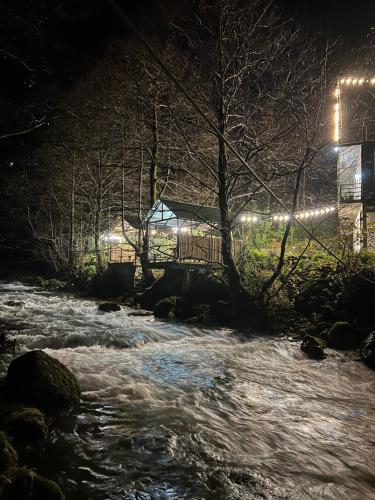 ein Fluss in der Nacht mit einem Haus im Hintergrund in der Unterkunft Rcheuli Villa in Charnali in Batumi