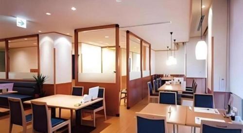 um restaurante com mesas e cadeiras num quarto em Kokura Recent Hotel em Kitakyushu