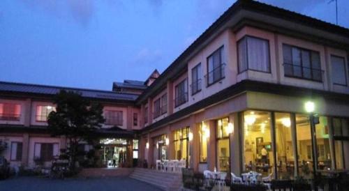 un gran edificio con mesas y sillas delante de él en Towadako Lakeside Hotel, en Towada