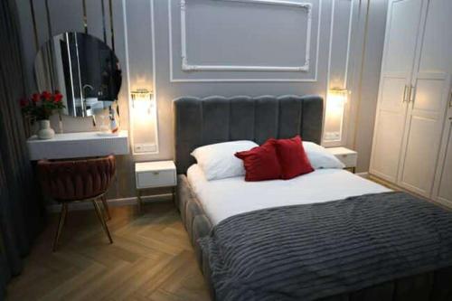 een slaapkamer met een bed met rode kussens en een raam bij Paris in Cracow Apartment in Krakau