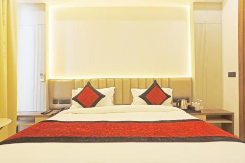 a bedroom with a large bed with red and white pillows at Hotel Mehul Int-New Delhi in New Delhi