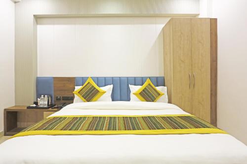 a bedroom with a large bed with yellow and blue pillows at Hotel Mehul Int-New Delhi in New Delhi