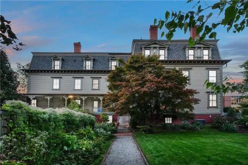 une grande maison grise avec un arbre dans la cour dans l'établissement The Underwood-Hale House, à Providence