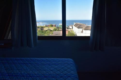 Schlafzimmer mit einem Fenster mit Meerblick in der Unterkunft cuatro lunas hotel in Punta Del Diablo