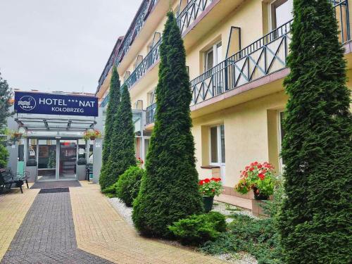 a row of trees in front of a building at Hotel *** NAT Kołobrzeg in Kołobrzeg