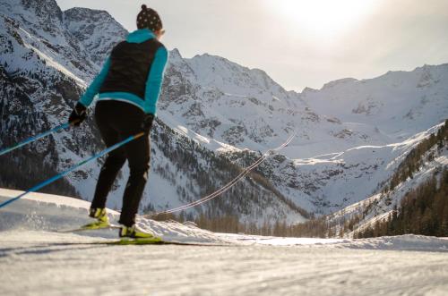 a person on skis in the snow with mountains at Glacier Rock guesthouse in Solda