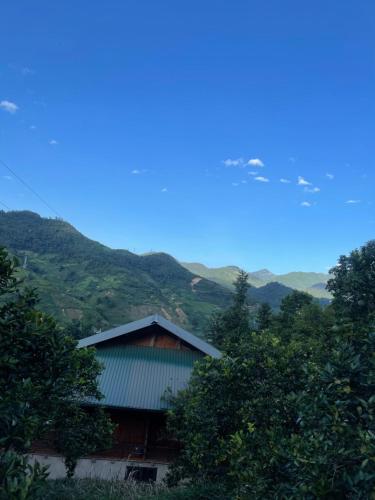 a building with mountains in the background at Sapa Orange Homestay in Sa Pa