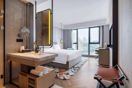 1 dormitorio con cama, lavabo y espejo en Wyndham Grand Plaza Royale Lugu Changsha, en Changsha