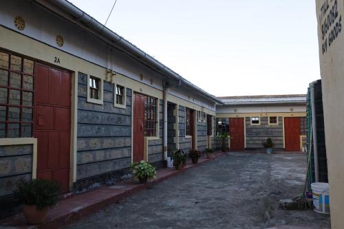 a row of buildings with red doors and potted plants at EUGENE HOMES Guest House in Gilgil