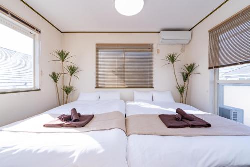 twee bedden in een slaapkamer met handdoeken erop bij Vivere in Tokyo