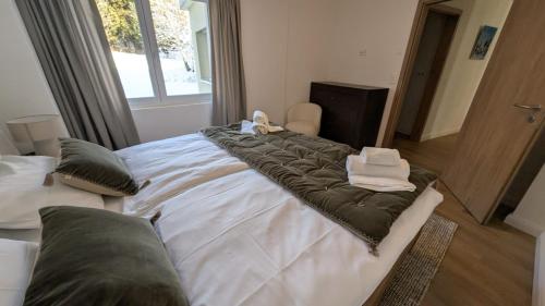 a large bed with a blanket on top of it at Le Belvedere By Alaïa in Crans-Montana