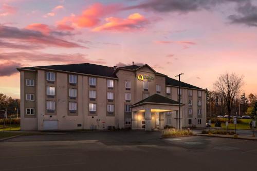 a hotel building with a sunset in the background at Quality Inn in Ottawa