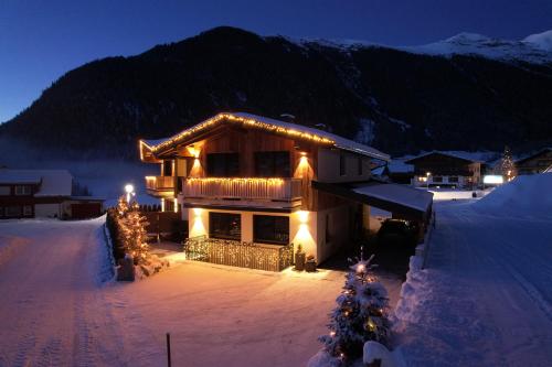 Una casa coperta di luci natalizie nella neve di Alp Apart Niederthai a Umhausen