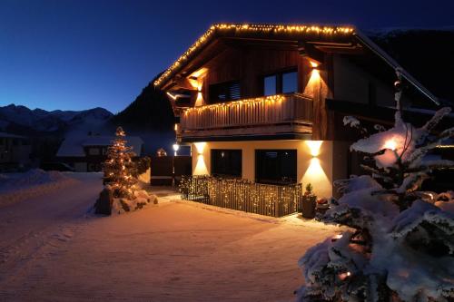 Una casa coperta di luci natalizie nella neve di Alp Apart Niederthai a Umhausen