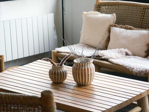 twee vazen op een houten tafel in een woonkamer bij ibis Caen Porte d’Angleterre in Hérouville-Saint-Clair