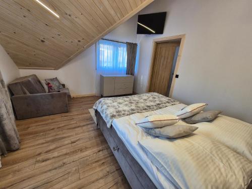 - une chambre avec un grand lit et un canapé dans l'établissement Apartament z jacuzzi U Parów, à Białka Tatrzańska