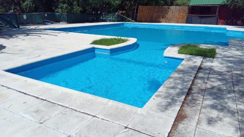 een zwembad met blauw water in een tuin bij JONATAN II Bed & Breakfast in Mina Clavero