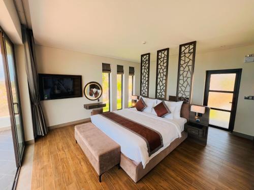 um quarto com uma cama grande e uma televisão em Du Parc Mũi Né Resort - ꜱᴀɴᴅ ᴅᴜɴᴇ & ᴏᴄᴇᴀɴ ᴠɪᴇᴡ em Mui Ne