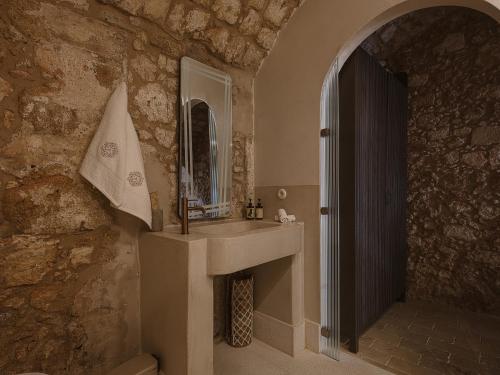 y baño con lavabo y espejo. en Aisha Hotel, en La Canea