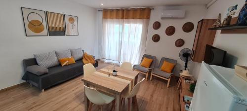 un soggiorno con divano, tavolo e sedie di LuengiHouse - Espectacular apartamento con piscina a Lloret de Mar