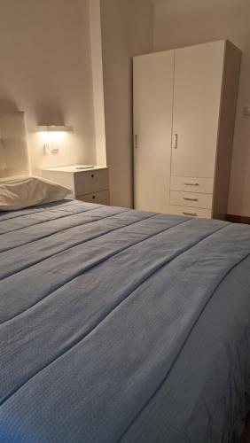 una camera da letto con un grande letto con lenzuola blu di A.l. KATEKERO a Costa Nova