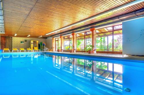 una grande piscina con acqua blu di WAGNERS Hotel im Fichtelgebirge a Warmensteinach